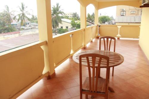 a balcony with two chairs and a table and a window at HOTEL MENABE in Morondava