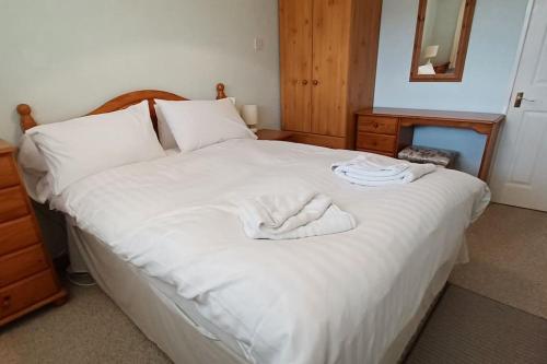 St Ann's 21 في Gunnislake: غرفة نوم عليها سرير وفوط بيضاء