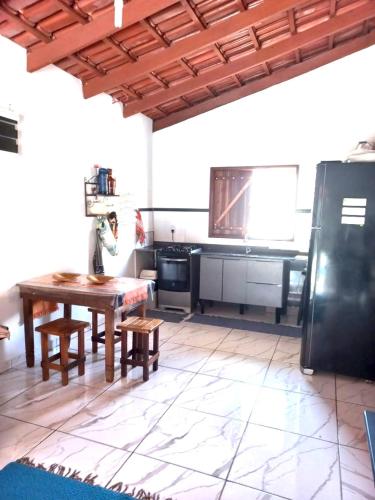 a kitchen with a wooden table and a refrigerator at Chácara buriti in Pirenópolis