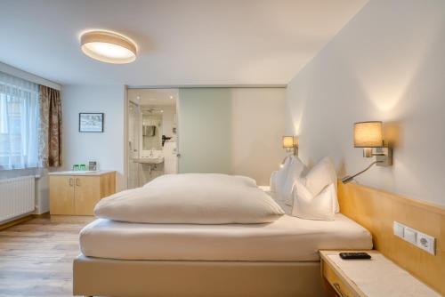 a bedroom with a large bed and a bathroom at Landhaus Maria in Stuben am Arlberg
