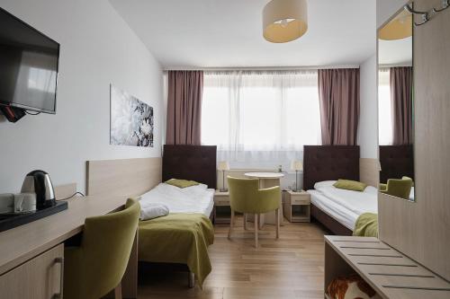 a hotel room with two beds and a table at Topaz dawniej Magnolia I in Świeradów-Zdrój