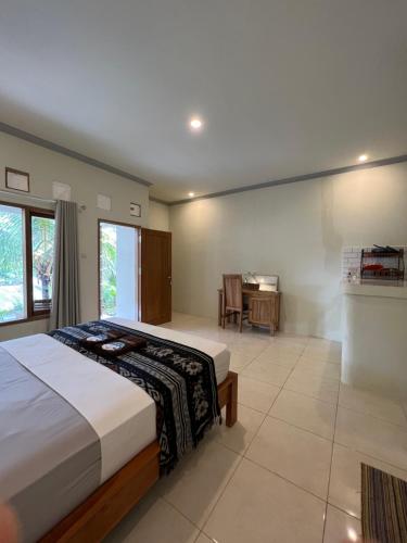 a bedroom with a bed and a desk in it at Kuta Circle Homestay in Kuta Lombok