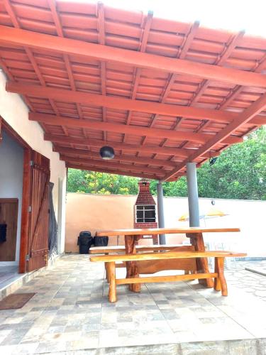 a wooden picnic table under a wooden roof at Chácara buriti in Pirenópolis