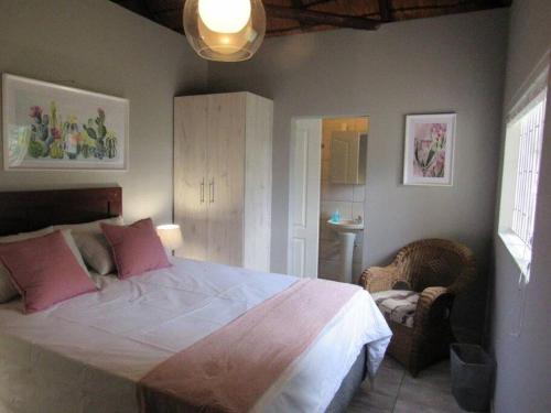 1 dormitorio con 1 cama grande con almohadas rosas en Lions Rest on Vaal River, en Vanderbijlpark