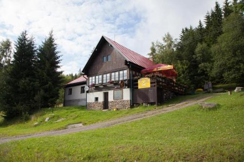 ein Gebäude an der Seite eines grasbewachsenen Hügels in der Unterkunft Chata Florian in Srní