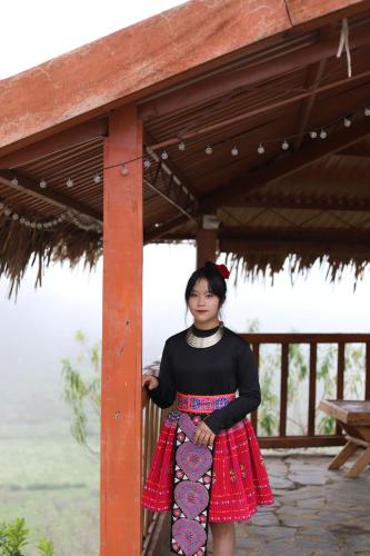 a woman standing under a pavilion holding a skateboard at Mộc Châu Peachy Garden in An Pon