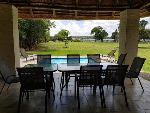 a table and chairs on a patio with a pool at Lions Rest on Vaal River in Vanderbijlpark