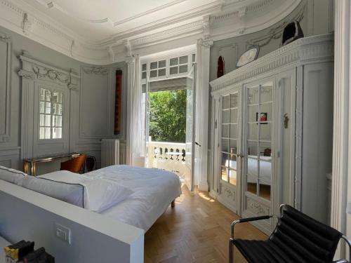 une chambre avec un grand lit et une fenêtre dans l'établissement Suite Célestine Palace Excelsior vue lac, à Aix-les-Bains