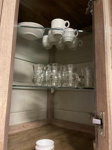 a shelf with cups and dishes on it at A Luxury 2 Bedroom With a perfect location in Sweifiyeh in Amman