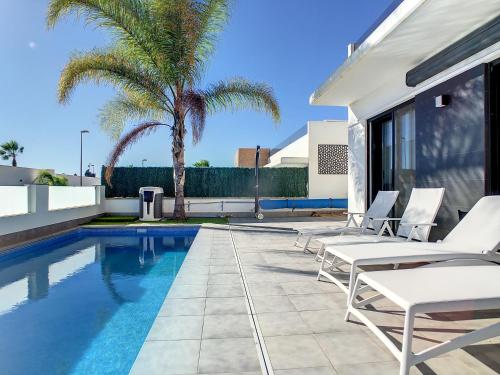 a swimming pool with lounge chairs next to a house at Villa Sur - Sucina - 8409 in Sucina