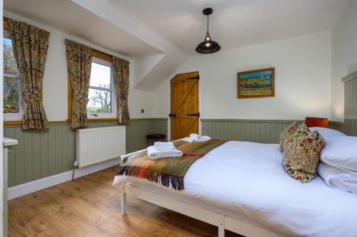 a bedroom with a large white bed and two windows at Meldrums Apartments in Ceres