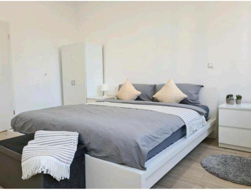 ein weißes Schlafzimmer mit einem großen Bett mit Kissen in der Unterkunft Ihr zu Hause auf Zeit! in Solingen