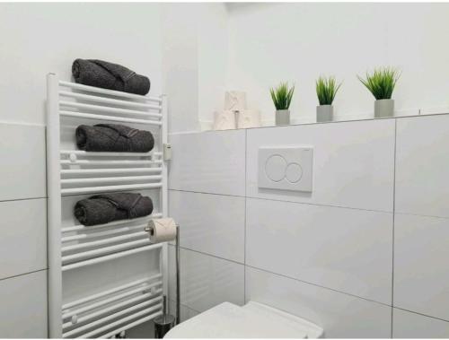 a white bathroom with a toilet and towels at Ihr zu Hause auf Zeit! in Solingen
