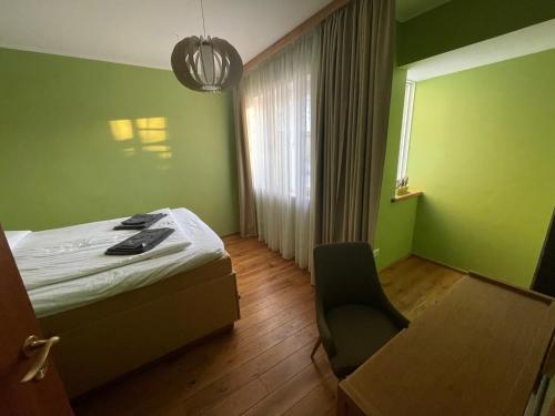 ein Schlafzimmer mit einem Bett, einem Stuhl und einem Fenster in der Unterkunft "Spring" apartment in Viljandi