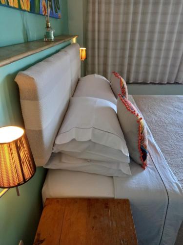 a bed with white sheets and pillows in a room at Casa Verde Río in Rio de Janeiro