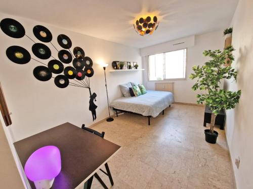 une chambre avec un lit et une table et une chambre avec un lit et des disques dans l'établissement GregBnb - Studio Design 25m2 - Ascenseur - WiFi - 10Min Gare, à Toulon