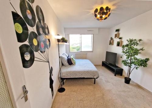 - une chambre avec un lit et un mur avec des disques dans l'établissement GregBnb - Studio Design 25m2 - Ascenseur - WiFi - 10Min Gare, à Toulon
