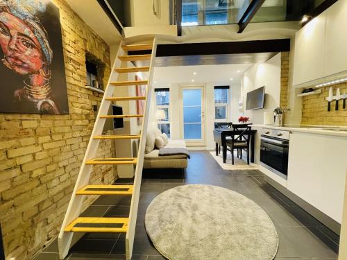 a loft bed in a room with a kitchen at Studio Apartment in the heart of Aalborg in Aalborg