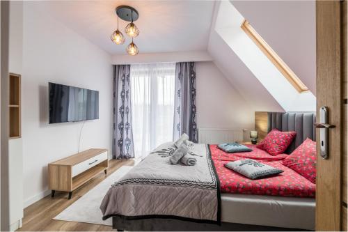 a bedroom with a bed with red pillows at Górski Apartament Białka Tatrzańska in Białka Tatrzańska