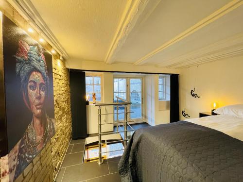 a bedroom with a large painting of a woman on the wall at Studio Apartment in the heart of Aalborg in Aalborg