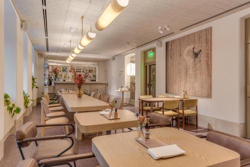 a restaurant with tables and chairs in a room at Sophia Hotel Kyiv in Kyiv