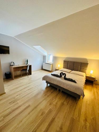 a large bedroom with a bed and a desk in it at Apartamenty Route 65 in Grabówka