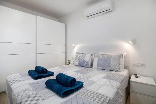 a bedroom with a bed with blue pillows on it at Casa Joyne in Puerto del Carmen