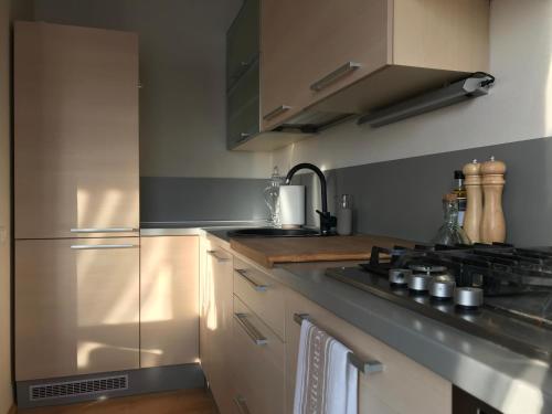 a kitchen with a stove and a stainless steel refrigerator at Upes apartamenti Nr: 32 in Valmiera