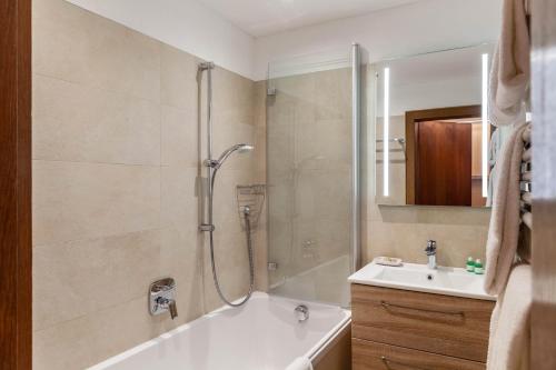 La salle de bains est pourvue d'une douche, d'une baignoire et d'un lavabo. dans l'établissement Haus Excelsior Top 29, à Seefeld in Tirol