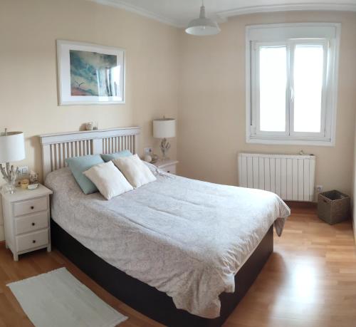a bedroom with a large bed and a window at Piso Prol in Ourense
