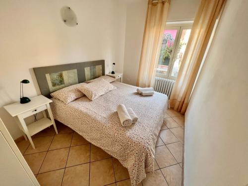 1 dormitorio con 1 cama con 2 toallas en Borgo Antico Apartments, en Toscolano Maderno