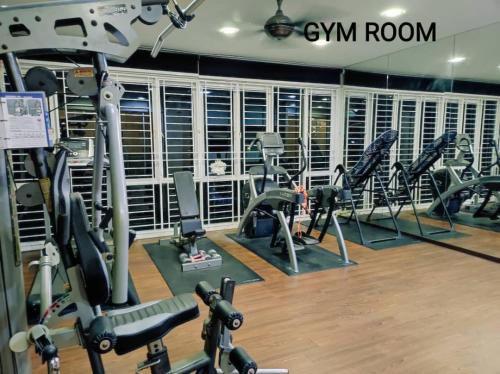 a gym with a bunch of treadms and cardio machines at Bungalow cheras hijauan residence HomeStay 6 bedrooms in Cheras