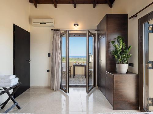 a hallway with a sliding glass door with a plant at Villa Hibiscus in Spiliá