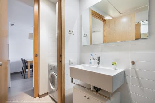 a bathroom with a sink and a washing machine at Flateli Navas D01 in Barcelona