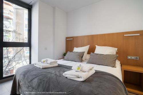 a bedroom with a large bed with towels on it at Flateli Navas D01 in Barcelona