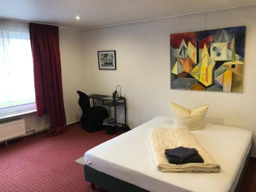 - une chambre avec un lit et une peinture murale dans l'établissement Hotel Saarland Lebach, à Lebach