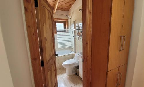 uma pequena casa de banho com um WC e uma janela em Turismo y Cabañas Dragon de La Patagonia em Cochrane