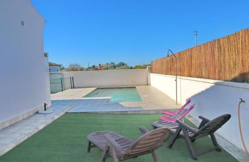 two chairs and a pool on the roof of a house at Chalet Lobita in Conil de la Frontera