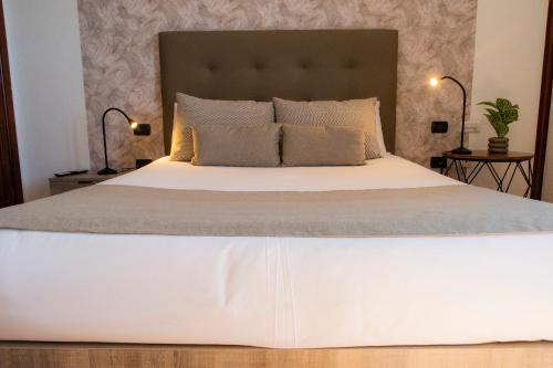a bedroom with a large white bed with two lamps at Hotel El Tejar & Spa in Vilaflor