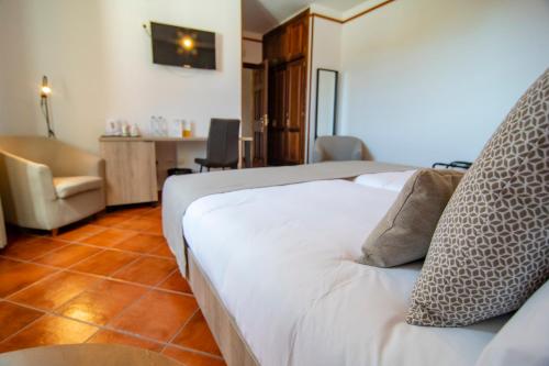 a bedroom with a bed with a chair and a desk at Hotel El Tejar & Spa in Vilaflor