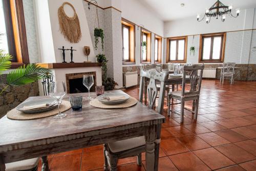 una sala da pranzo con tavolo, sedie e camino di Hotel El Tejar & Spa a Vilaflor de Chasna