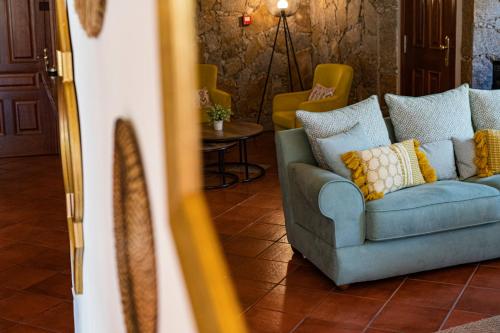 a living room with a blue couch and yellow pillows at Hotel El Tejar & Spa in Vilaflor