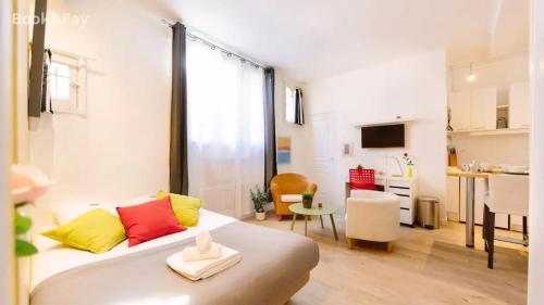 Cette chambre comprend un lit avec des oreillers jaunes et rouges. dans l'établissement Studio petit LU, à Nantes