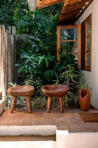 two stools sitting next to a building with plants at DA GRAÇA HOTEL in Trancoso