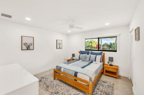 a bedroom with a bed and a window at Sandals Beach Cottage in Fort Lauderdale