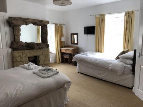 a bedroom with two beds and a stone fireplace at The Sun Rooms in Alnmouth