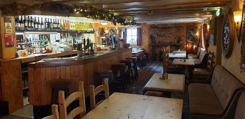 eine Bar mit Holztischen und -stühlen in einem Restaurant in der Unterkunft The Sun Rooms in Alnmouth