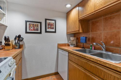 una cocina con armarios de madera y fregadero en The Aspen Glow, en Durango Mountain Resort