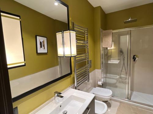 a bathroom with a sink and a toilet and a mirror at Napoli Mariana Luxury in Naples