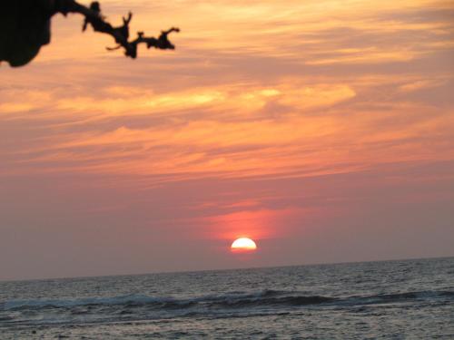 a sunset on the beach with the sun in the sky at Bentota Home Stay in Bentota